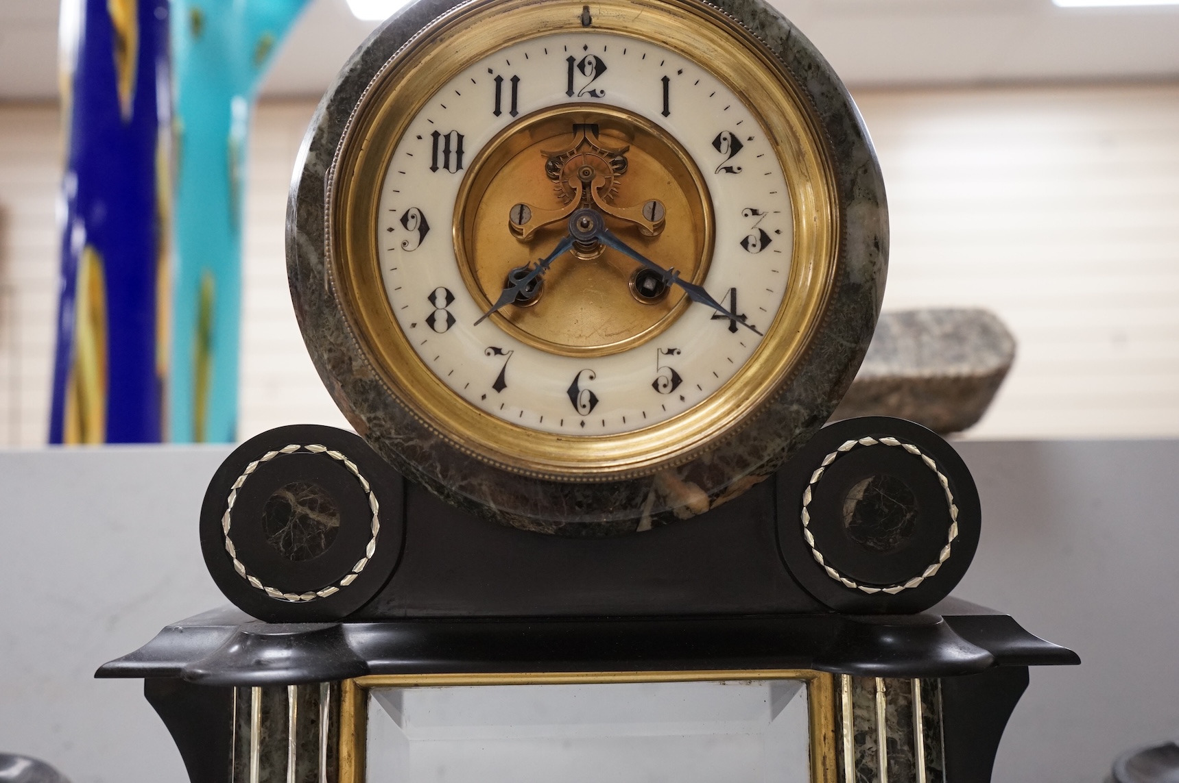 A Victorian slate clock garniture with enamelled chapter ring and mercury pendulum, 47cm high